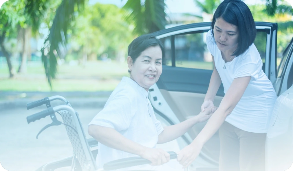 Caregiver-helps-senior-woman-in-wheelchair-get-into-car-to-head-to-a-doctors-appointment-